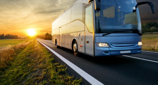 Bus-traveling-on-the-asphalt-road-in-rural-landscape-at-sunset1
