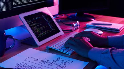 Close-up image of programmer working at his desk in office